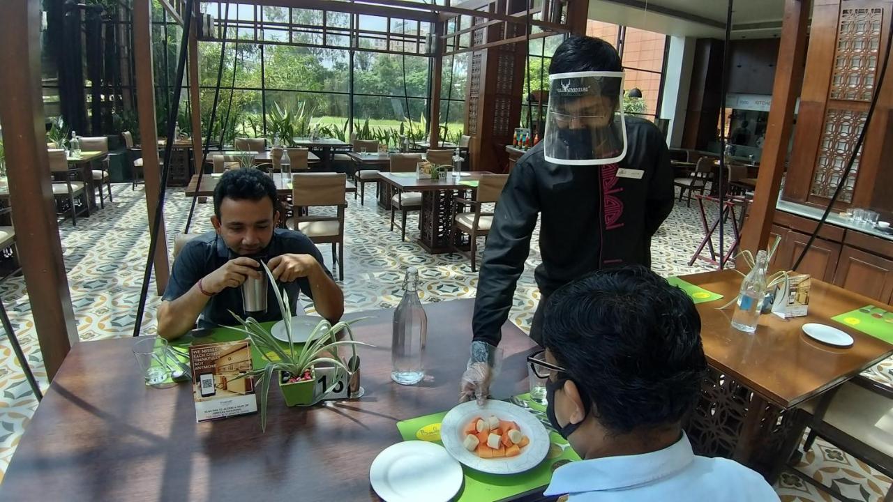 The Orchid Hotel Hinjewadi Pune Esterno foto A restaurant in India with a waiter wearing a face shield